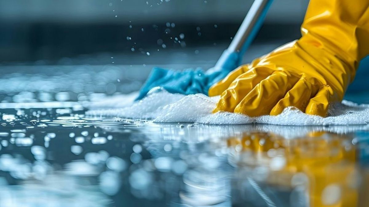 Professionelle Bodenreinigung mit Schutzhandschuhen